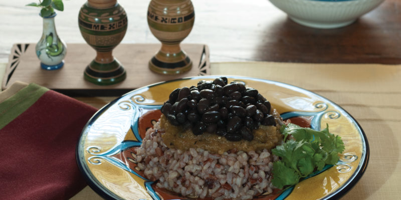 bean and rice with hatch green chile sauce on a decorative plate