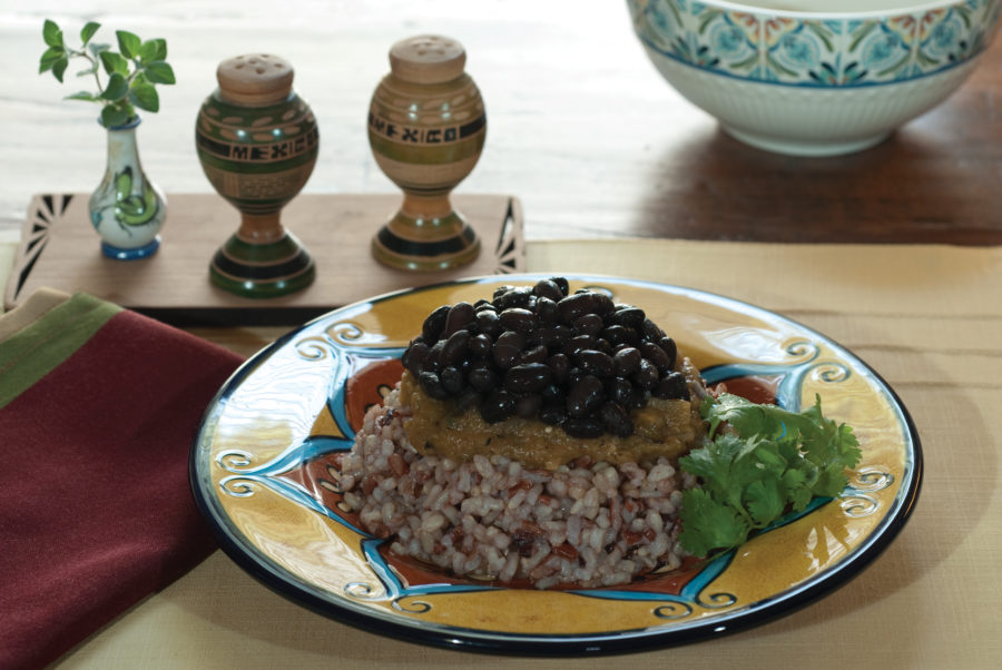 bean and rice with hatch green chile sauce on a decorative plate