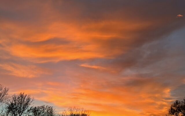 An autumn sunset illuminating the under side of the clouds with an orange glow